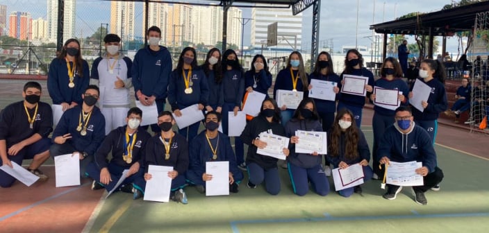 Grupo de alunos exibindo seus certificados das olimpíadas